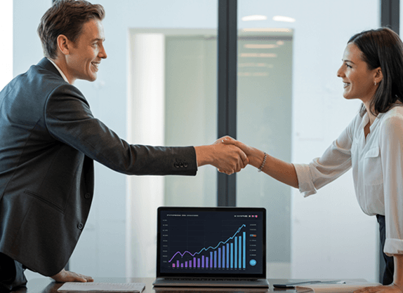 Business professionals shaking hands in office meeting